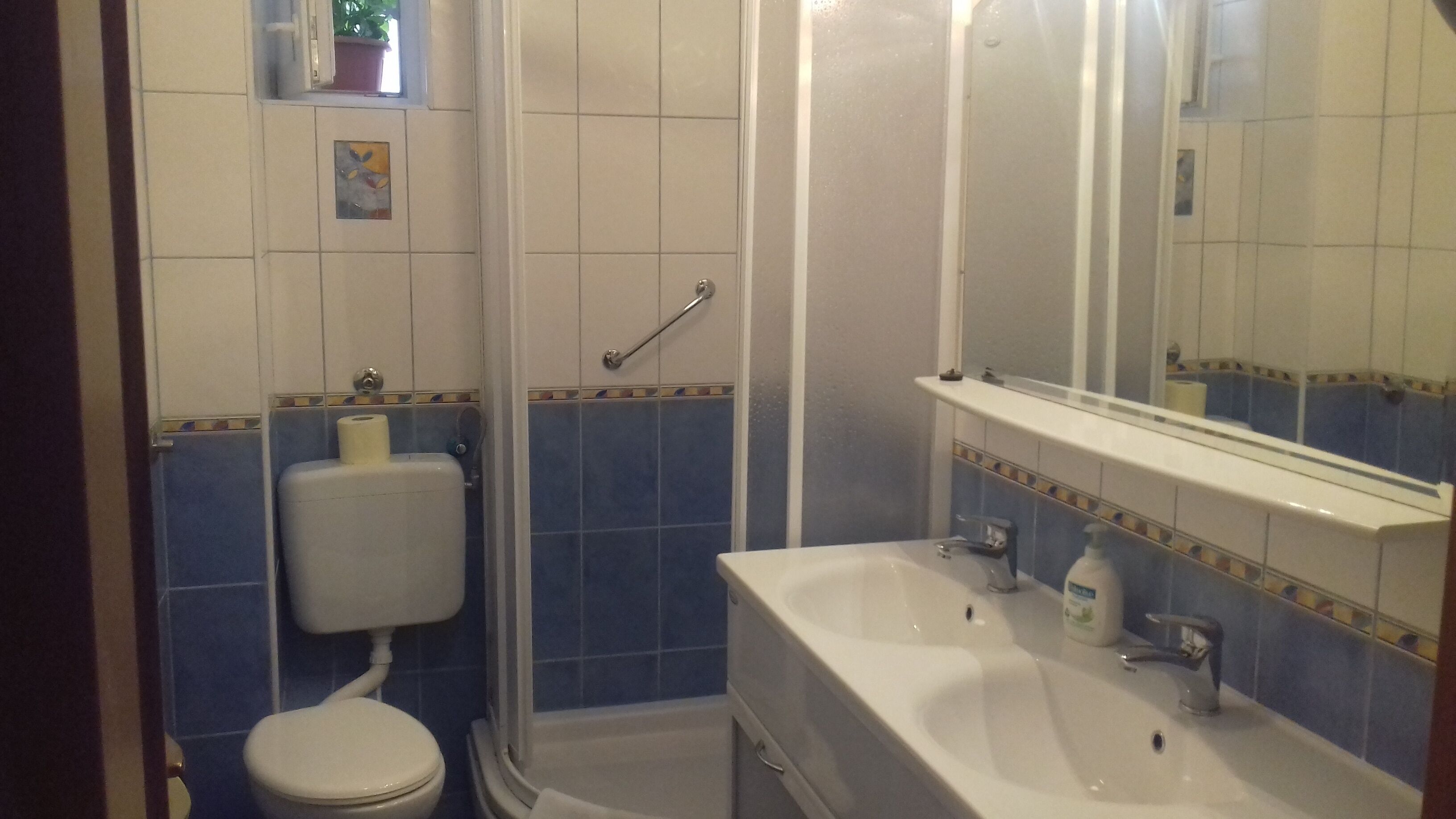 A bathroom with a toilet, sink, and shower.