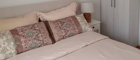 Un dormitorio con cama, armario y candelabro.