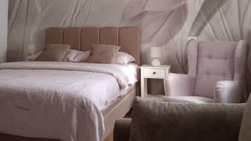 A bedroom with a bed, nightstand, chair, and a wall mural.