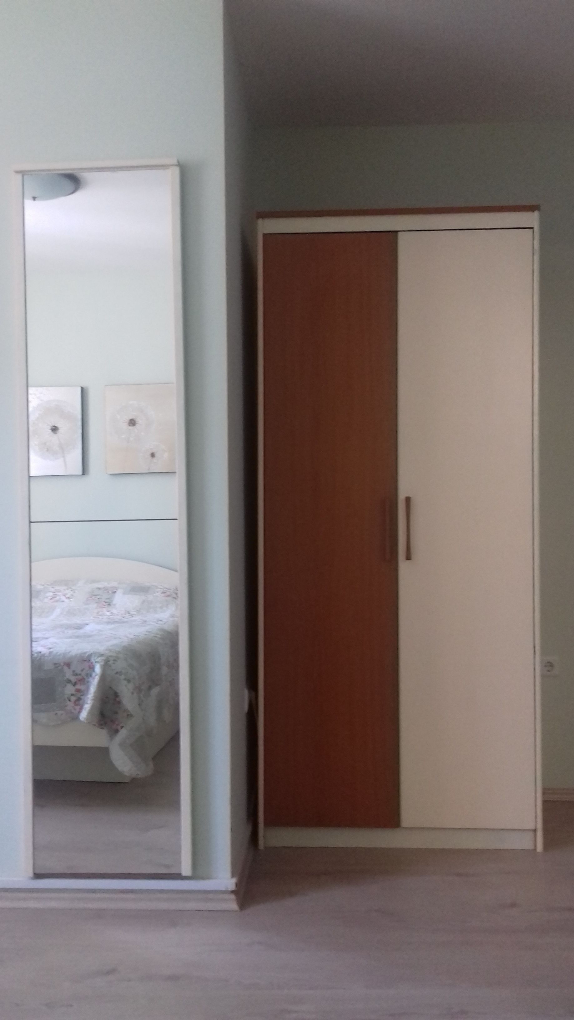 Une chambre à coucher avec un lit, une armoire et un miroir.