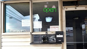 A motel with a 'OPEN' sign, a photo ID requirement, and a 'PLEASE RING FOR SERVICE' sign.