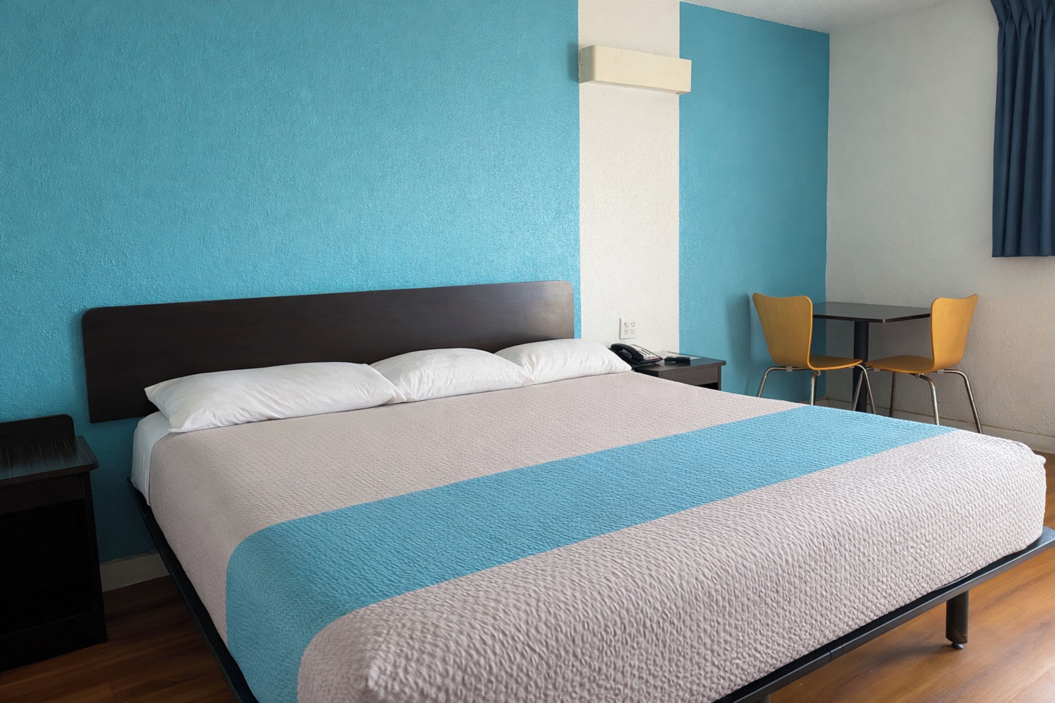 Une chambre d’hôtel avec un grand lit, un bureau et deux chaises.
