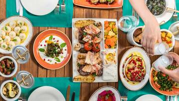 A table set with various dishes, including meat, vegetables, and dips, suggesting a meal setting.