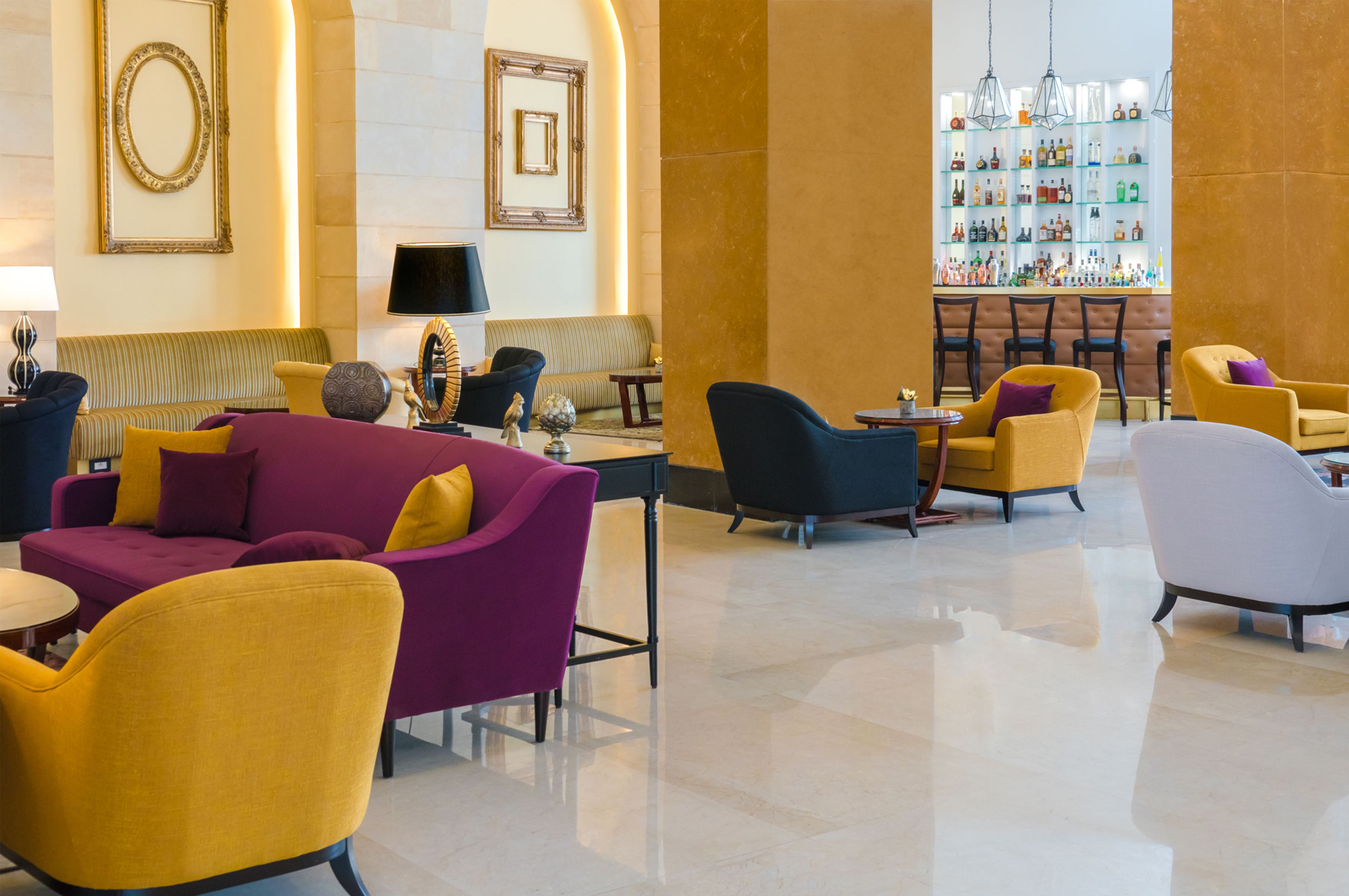 Un hall con zona de bar, sofás y sillones.