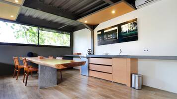 Una cocina moderna con una mesa de comedor de madera, sillas y un horno empotrado.