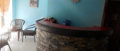 A reception area with a stone counter, a clock, and a framed picture on the wall.