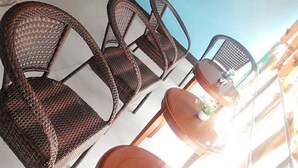 A room with wicker chairs, a small round table with a flower, and a framed picture on the wall. - Asia Novo Boutique Hotel - Dumaguete (Dumaguete)