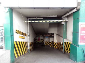 Einfahrt zu einer Parkgarage mit Hinweisschildern und einer Warnung bezüglich der Durchfahrtshöhe.