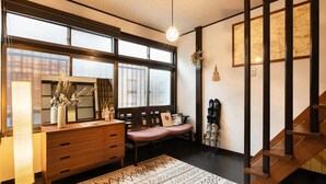 A cozy room with a wooden desk, a bench, and a staircase. - Shiori (Kyoto)