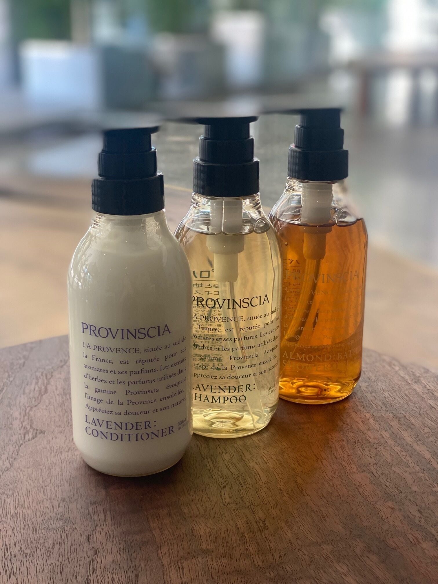 Three bottles of Provinscia products on a wooden surface.