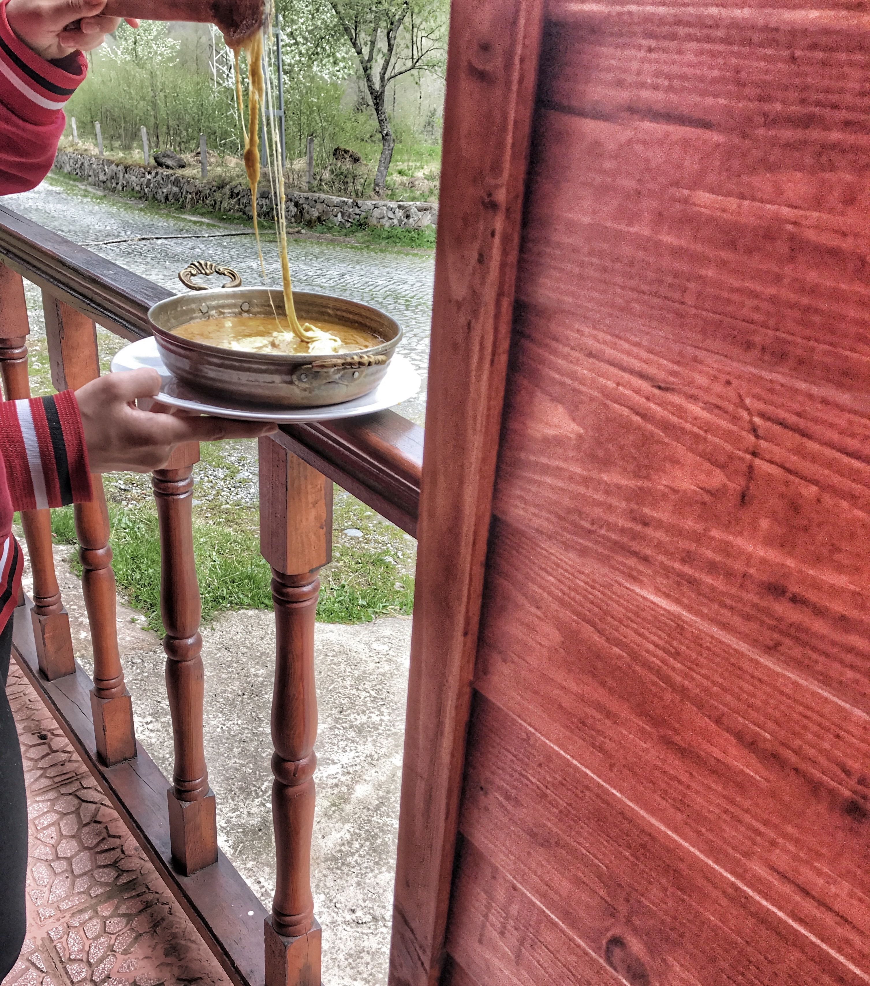 A person pouring soup from a bowl onto a plate.