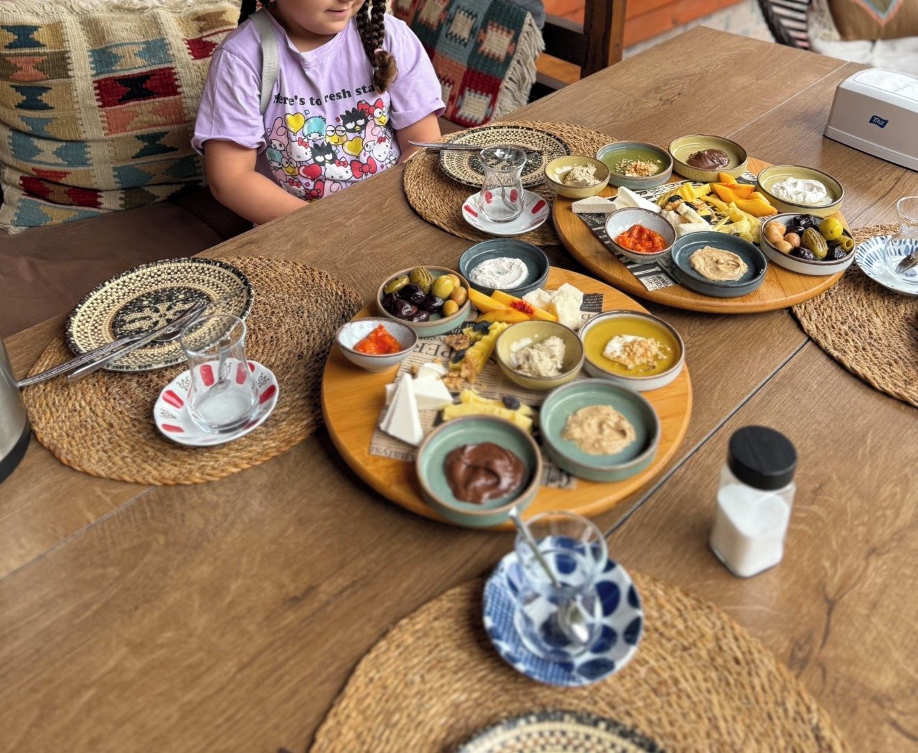 Una mesa dispuesta con diferentes alimentos y condimentos, indicando el momento de una comida o un refrigerio.