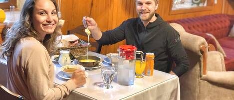 A dining table with a meal, a pitcher, a glass of orange juice, and a can of soda.