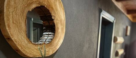 A hallway with a wooden wall decor, a mirror, and a door.