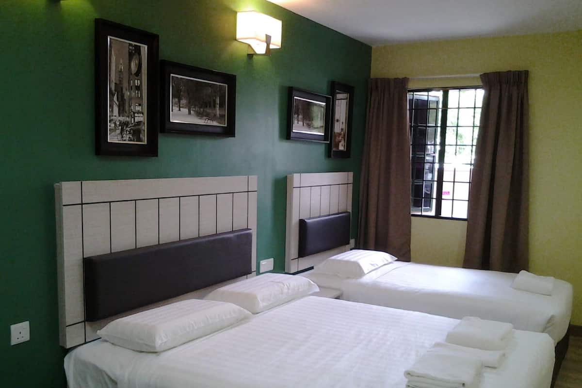 A hotel room with two beds, a window with curtains, and wall-mounted pictures.