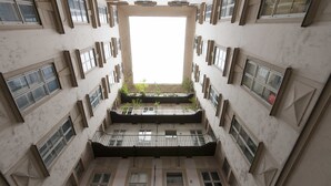 A multi-level atrium with a central open space surrounded by balconies and windows. - Heart of Vienna Apartments (Vienna)