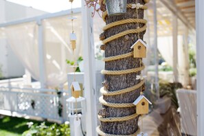 A tree trunk with multiple birdhouses and ropes.