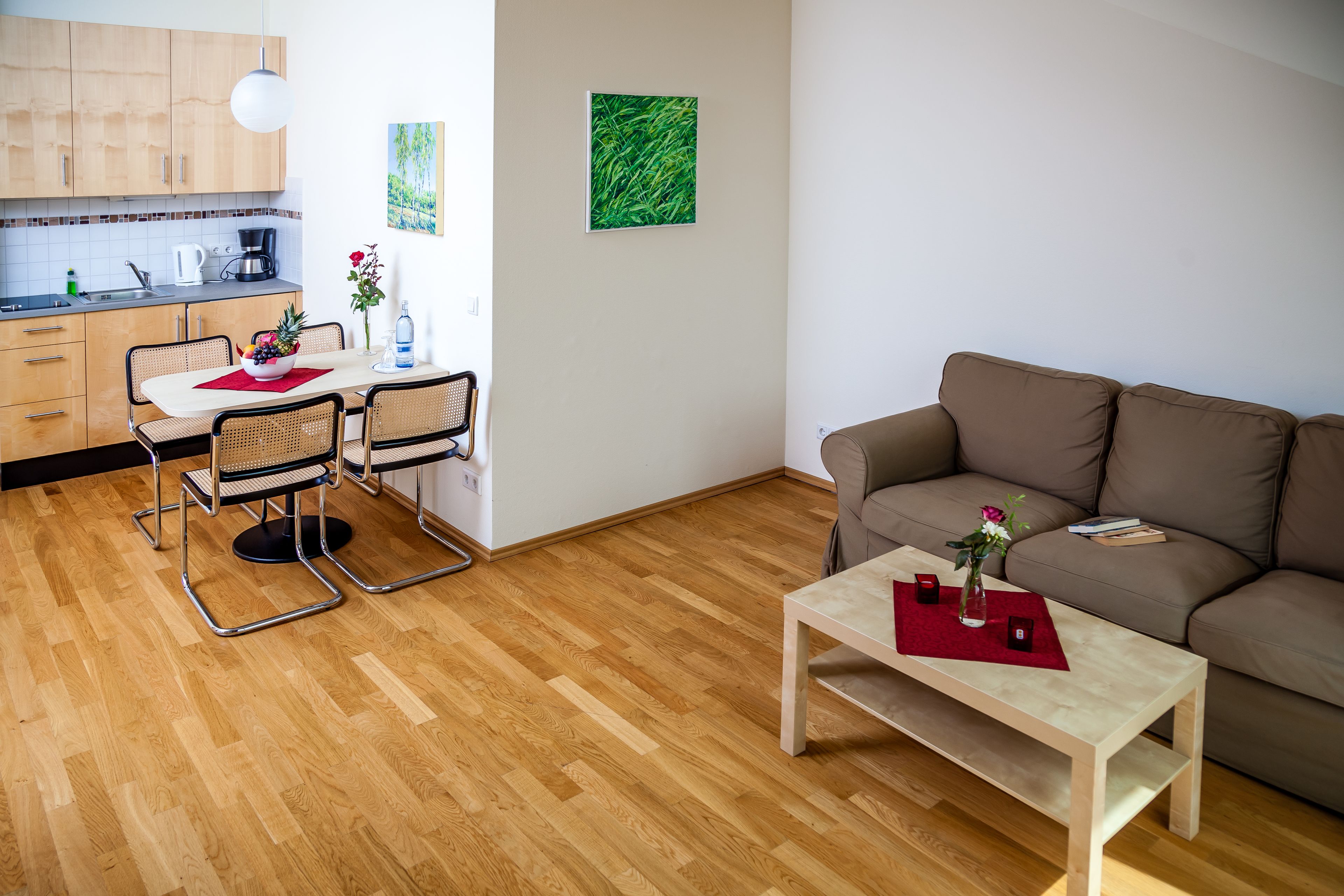 Un salon moderne avec un canapé marron, une table basse en bois et un coin repas comprenant une table et des chaises.