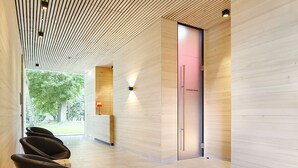 A modern waiting area with wooden paneling, a reception desk, and a door marked "Umweltlebe herten." - Spa Hotel Amsee (Waren (Müritz))