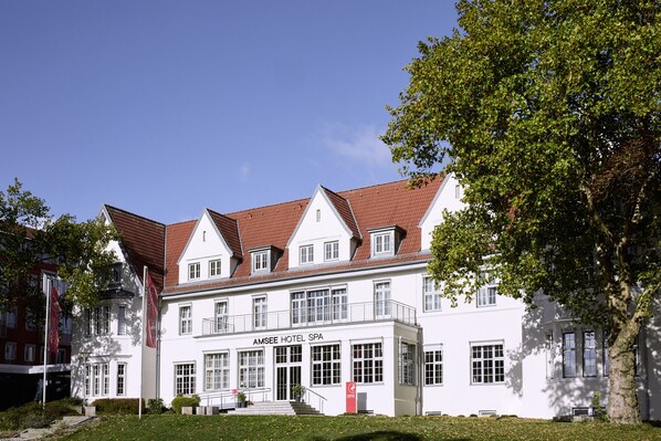 A large, white building with a red roof, labeled "AMSEE HOTEL SPA," featuring multiple windows and a central entrance. - Spa Hotel Amsee (Waren (Müritz))
