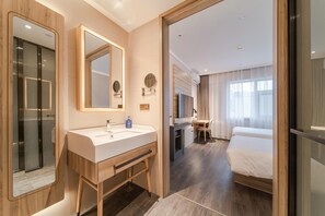 A hotel room with a bathroom, a bed, a desk, and a TV. - Hanting Hotel (Beijing)