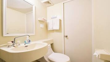 A bathroom with a sink, mirror, toilet, and towel rack.