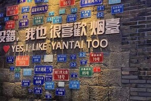 A wall with numerous apartment numbers and a large sign that reads "YES, I LIKE YANTAI TOO" with a heart symbol. - Ginza Jiayi Hotel (Yantai Suocheng Wanda Plaza Branch) (Yantai)
