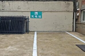 A parking area with a concrete surface, a white line marking, and a green sign with white text. - Ginza Jiayi Hotel (Yantai Suocheng Wanda Plaza Branch) (Yantai)