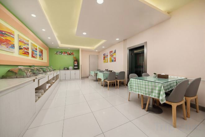 Un comedor con mesa de vidrio, sillas y mostrador con alimentos.