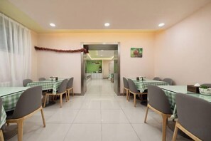 A hotel dining area with tables and chairs, a corridor leading to other rooms, and a door with a sign. - Ginza Jiayi Hotel (Yantai Suocheng Wanda Plaza Branch) (Yantai)