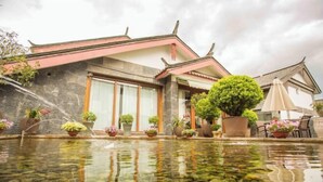 Un bâtiment de style japonais traditionnel, avec un bassin à carpes koï devant.