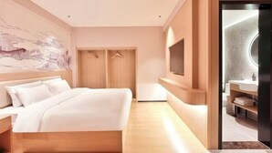 A modern hotel room with a bed, a wardrobe, a TV, and a bathroom. - ELONG R YUNHotel (Ningbo Yonggang North Road) (NINGBO)