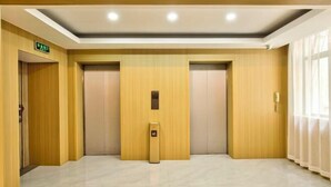 A modern elevator area with two elevators, a control panel, and a ceiling with recessed lighting. - ELONG R YUNHotel (Ningbo Yonggang North Road) (NINGBO)