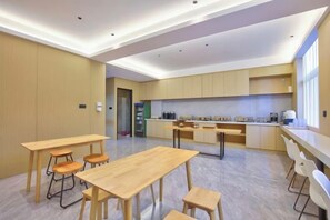 A modern kitchen with wooden cabinets, a central island, and bar stools. - ELONG R YUNHotel (Ningbo Yonggang North Road) (NINGBO)