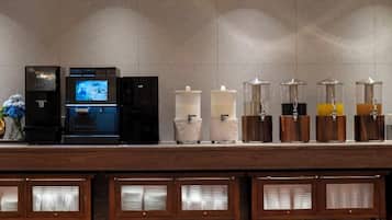 A beverage station with a coffee machine, a water dispenser, and various drink dispensers.