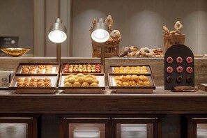 A bakery display with various baked goods and a decorative sign. - Fuyuan Hotel (Zhengzhou East Station Provincial Government Branch) (Zhengzhou)