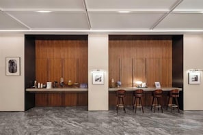 A modern bar area with wooden paneling, bar stools, and framed artwork on the walls. - Fuyuan Hotel (Zhengzhou East Station Provincial Government Branch) (Zhengzhou)