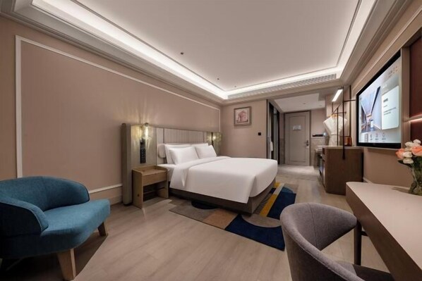 A hotel room with a bed, bedside tables, a desk, a chair, and a television. - Fuyuan Hotel (Zhengzhou East Station Provincial Government Branch) (Zhengzhou)