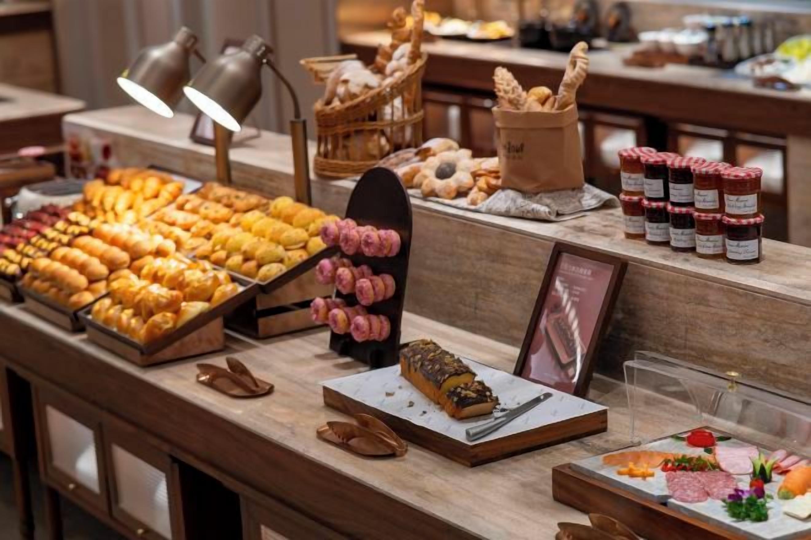 A buffet with various food items and a display of pastries.