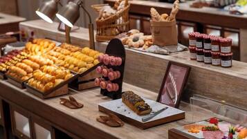 A buffet with various food items and a display of pastries.
