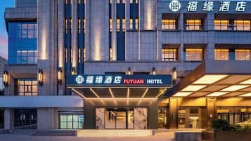 A hotel entrance with a modern facade, a prominent signage, and a well-lit entrance area.
