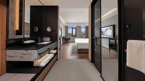Une salle de bain moderne avec un grand miroir, un lavabo et un meuble-lavabo.