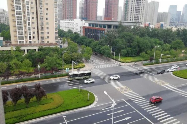A multi-lane intersection with a bus, cars, and a pedestrian crossing. - Fuyuan Hotel (Zhengzhou East Station Provincial Government Branch) (Zhengzhou)