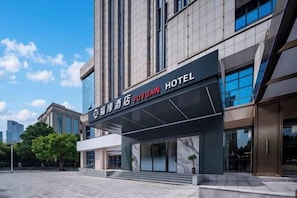 Een hotelgevel met een modern ontwerp, grote ramen en een heldere lucht.