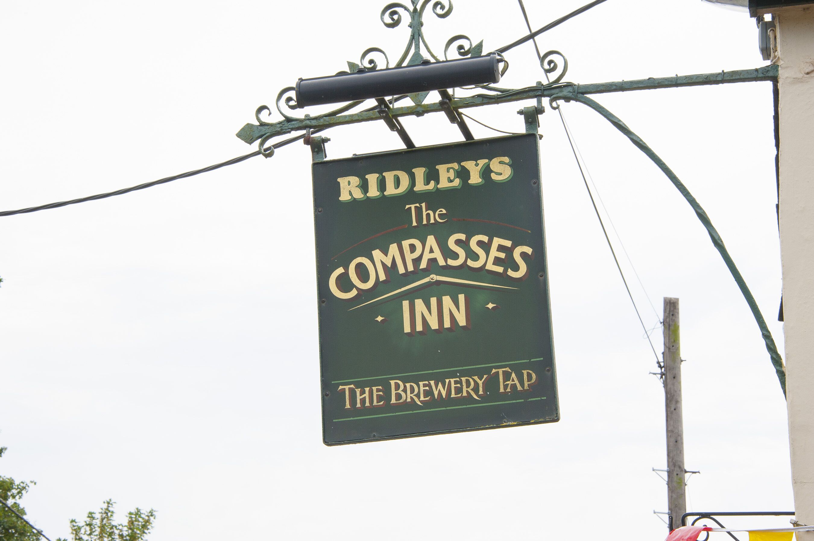 Une enseigne indiquant l’emplacement du « The Compass Inn » de Ridley, et précisant qu’il s’agit d’un débit de bière de la brasserie.