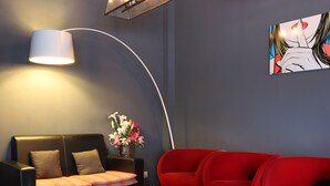 A modern living room with a black leather sofa, a red sofa, a white coffee table, and a floor lamp. - Hotel O Link Inn (Johor Bahru)