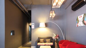 A modern lobby with a sofa, red chairs, a white table, and a lamp. - Hotel O Link Inn (Johor Bahru)