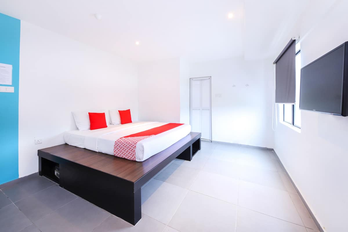 A modern bedroom with a bed, a TV, and a sliding door.