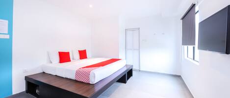 Un dormitorio moderno con cama, televisión y puerta corredera.