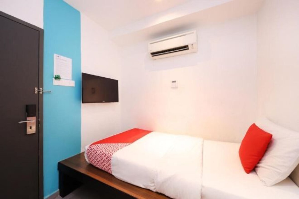 Una stanza moderna e luminosa con un letto, una scrivania e un condizionatore d'aria a parete.